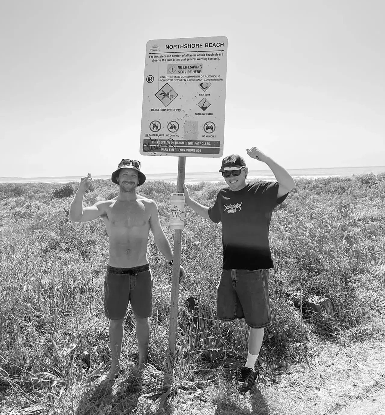 Two of the Bite Aid crew at a beach access sign on the Mid-North Coast